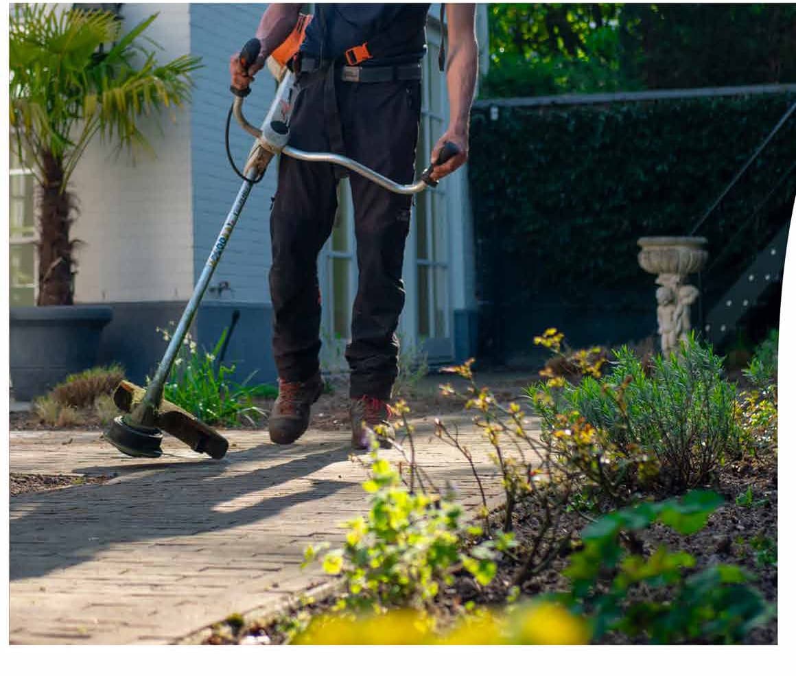 Landscape gardener strimming a garden path in Shrewsbury